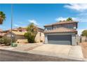 Two-story home with red tile roof and two-car garage in a neighborhood with desert landscaping at 10162 Lemon Thyme St, Las Vegas, NV 89183