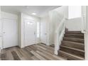 Bright foyer features wood laminate flooring, coat closet and leads to a staircase with glass panel at 10162 Lemon Thyme St, Las Vegas, NV 89183