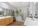 Well-lit bathroom with double sinks, soaking tub, and glass-enclosed shower at 1079 Oak Shade Ln, Henderson, NV 89015