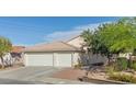Charming home featuring a well-manicured lawn, mature tree, and a convenient three-car garage at 1079 Oak Shade Ln, Henderson, NV 89015