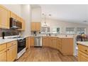 Bright kitchen with stainless steel appliances, light wood cabinets, and modern countertops at 1079 Oak Shade Ln, Henderson, NV 89015