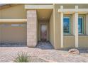 Close-up showcasing front door with stone accents, a brick walkway, and desert landscaping at 12438 Heritage Bend Dr, Las Vegas, NV 89138