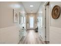 Bright hallway with wood floors, white wainscoting, and a skylight for natural light at 12438 Heritage Bend Dr, Las Vegas, NV 89138