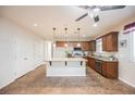 Open kitchen with a granite island, stainless steel appliances, and warm wood cabinetry at 132 Soaring Sky Ave, Henderson, NV 89011