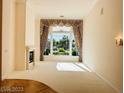 Bright living room with a fireplace, large window with curtains and plush carpeting at 2017 Eagle Trace Way, Las Vegas, NV 89117