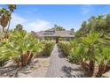 Inviting single-story home boasts lush landscaping and a brick walkway to the front door at 2222 Lucerne Ct, Henderson, NV 89014