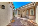 Covered front porch with a white front door and decorative plants at 2544 Ashley Rose Ter, Henderson, NV 89052