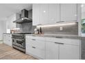 Modern kitchen boasts sleek white cabinets, stainless steel appliances, and marble countertops at 3630 Tobias Ln, Las Vegas, NV 89120