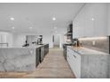Open-concept kitchen features white cabinets, marble countertops, and stainless steel appliances at 3630 Tobias Ln, Las Vegas, NV 89120