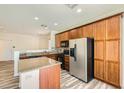 Modern kitchen featuring an island with granite countertops, wood cabinets and stainless appliances at 3636 Remington Grove Ave, North Las Vegas, NV 89081