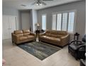Bright living room with neutral tones, tile flooring, and comfortable seating at 3720 Rocklin Peak Ave, North Las Vegas, NV 89081