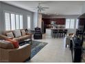 Open living room features tile floors, large windows with shutters, and flows into the kitchen at 3720 Rocklin Peak Ave, North Las Vegas, NV 89081