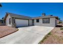 A single-story home featuring an attached garage, gravel yard, and a long driveway at 4484 Bennett Dr, Las Vegas, NV 89121
