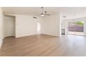 Bright open-concept living room with light wood floors, a ceiling fan, and seamless access to the kitchen at 5751 Mabel Rd, Las Vegas, NV 89110