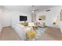 Open-concept living room featuring light wood floors, large screen television, and comfortable seating at 5751 Mabel Rd, Las Vegas, NV 89110