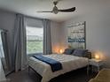 Cozy bedroom featuring modern ceiling fan, stylish decor, and plenty of natural light through the window at 6650 W Warm Springs Rd # 2159, Las Vegas, NV 89118