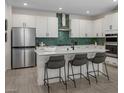 Modern kitchen with stainless steel appliances, white cabinetry, and a center island with bar seating at 737 Wild Highlands Ln, Henderson, NV 89015