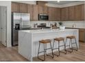 Stylish kitchen boasts stainless steel appliances, white quartz countertops, island with seating, and wood cabinets at 739 Wild Highlands Ln, Henderson, NV 89015