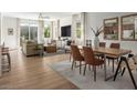 Bright, open-concept living space featuring wood floors, modern furnishings, and seamless flow into dining area at 739 Wild Highlands Ln, Henderson, NV 89015