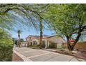 Two story home with a long driveway, three-car garage, desert landscaping, and tile roof at 8104 Wispy Sage Way, Las Vegas, NV 89149