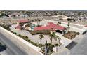 Aerial view of a sprawling estate featuring a red tile roof, palm trees, and a sparkling blue pool at 10280 W La Mancha Ave, Las Vegas, NV 89149