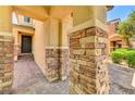 Inviting front porch showcasing stone-clad columns and a beautifully paved walkway to the front door at 10805 Cain Ave, Las Vegas, NV 89166