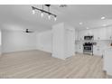 Open floor plan with light wood floors, modern lighting fixtures, and a seamless flow at 1115 W Nelson Ave, North Las Vegas, NV 89030