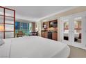 Bright bedroom showcasing a king bed, kitchenette, and city views through the balcony door at 135 E Harmon Ave # 315, Las Vegas, NV 89109