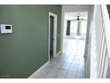Bright hallway with tile flooring, light walls, and open view into another living space with large windows at 1703 Game Garden Rd, North Las Vegas, NV 89031