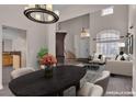 Virtually staged dining room with stylish chandelier and view into the living area at 1717 Double Arch Ct, Las Vegas, NV 89128