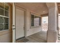 Inviting front entryway with a covered porch, white door, and neutral-toned exterior at 209 Prairie Creek St, Henderson, NV 89012