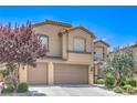 Charming two-story home featuring a well-manicured lawn and a two-car garage, nestled under a bright blue sky at 2189 De Narvik Dr, Henderson, NV 89044