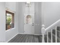 Bright entryway featuring wood-look floors, a decorative front door, and a staircase at 2231 Desert Prairie St, Las Vegas, NV 89135