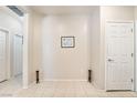 Neutral hallway featuring tile flooring, artwork, and multiple doorways at 2326 Garnet Star St, Henderson, NV 89044