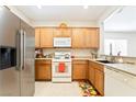 Well-lit kitchen boasts wood cabinetry, white appliances, and tiled floors at 2326 Garnet Star St, Henderson, NV 89044