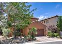 View of a two-story home with a brick driveway and landscaped front yard and desert landscaping at 2373 Rue Royale St, Henderson, NV 89044
