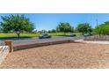Expansive front yard featuring low-maintenance landscaping and mature trees in a serene neighborhood setting at 2432 Spanish Ct, Las Vegas, NV 89108