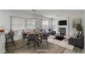 Open concept living and dining area with modern furniture and ample natural light from large windows at 2573 Rafferty Creek Ln, Las Vegas, NV 89156