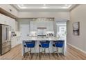 Bright kitchen features an island with blue stools and a stunning chandelier, perfect for modern living at 2714 Langlade Ave, Henderson, NV 89052