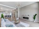 Open-concept living area flows into a modern kitchen, featuring sleek furnishings and a cozy fireplace at 2714 Langlade Ave, Henderson, NV 89052