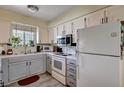 Bright kitchen with white and gray cabinets, modern appliances, and a window overlooking the yard at 2725 S Nellis Blvd # 1038, Las Vegas, NV 89121