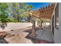 Private backyard features a covered patio, decorative rock, and mature trees at 2904 Channel Bay Dr, Las Vegas, NV 89128
