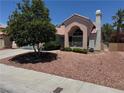 Well-maintained home with a tile roof, decorative chimney, manicured bushes and desert landscaping at 2904 Channel Bay Dr, Las Vegas, NV 89128
