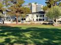 Exterior of a modern white house set on a golf course with well-manicured lawn and mature trees at 2989 Bel Air Dr, Las Vegas, NV 89109