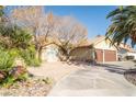 Beautiful home with a landscaped front yard, mature trees, and a curved driveway leading to a two-car garage at 3436 N Tenaya Way, Las Vegas, NV 89129