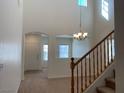 Light and bright entryway with neutral carpet, tile entry and wooden banister at 3728 Prairie Orchid Ave, North Las Vegas, NV 89081
