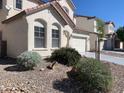 Desert landscaping surrounds this two-story home featuring multiple architectural window designs at 3728 Prairie Orchid Ave, North Las Vegas, NV 89081