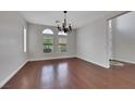 Elegant dining room with wood floors, a chandelier, and large windows offering natural light at 3728 White Lion Ln, North Las Vegas, NV 89084