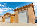 Spacious multi-car garage featuring bright white doors and contrasting stucco design at 3811 Queen Elizabeth Ct, Laughlin, NV 89029
