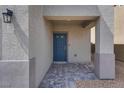 Covered entrance with a blue front door and stone paver landing at 4448 Mahogany Hills Ave, Las Vegas, NV 89141